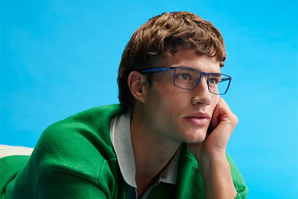 Uomo biondo con occhiali da vista guarda verso destra, espressione neutra.