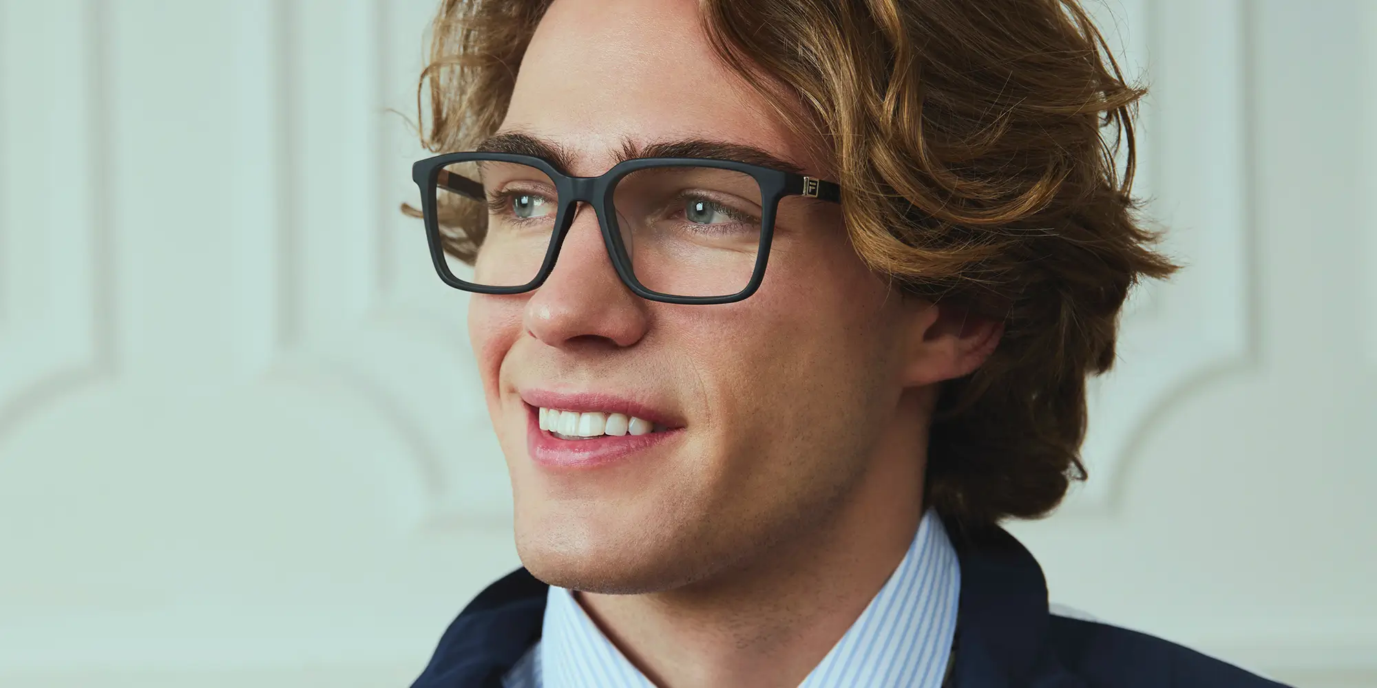 Uomo sdraiato con occhiali da vista, guarda in alto con la testa su una racchetta.